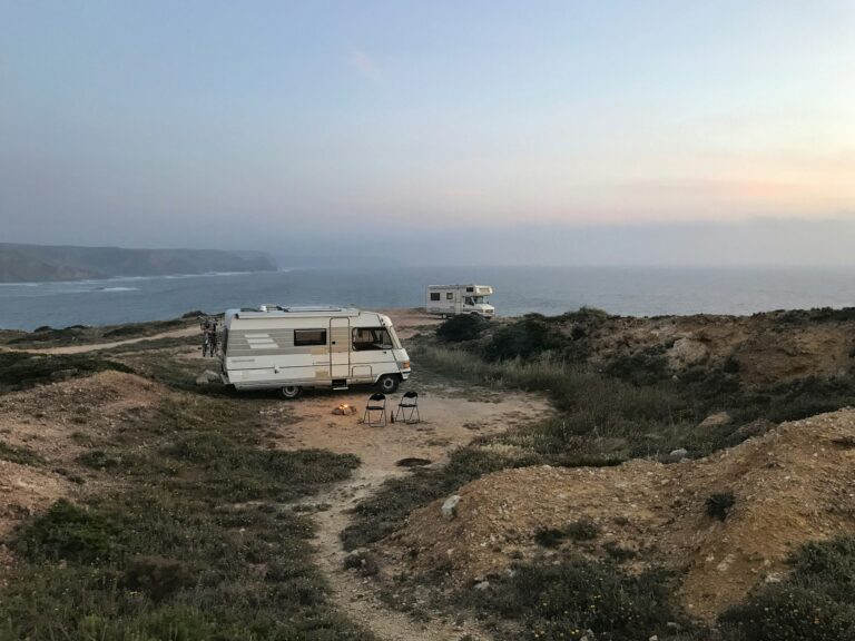 Clean white and brown RV parked under a clear blue sky