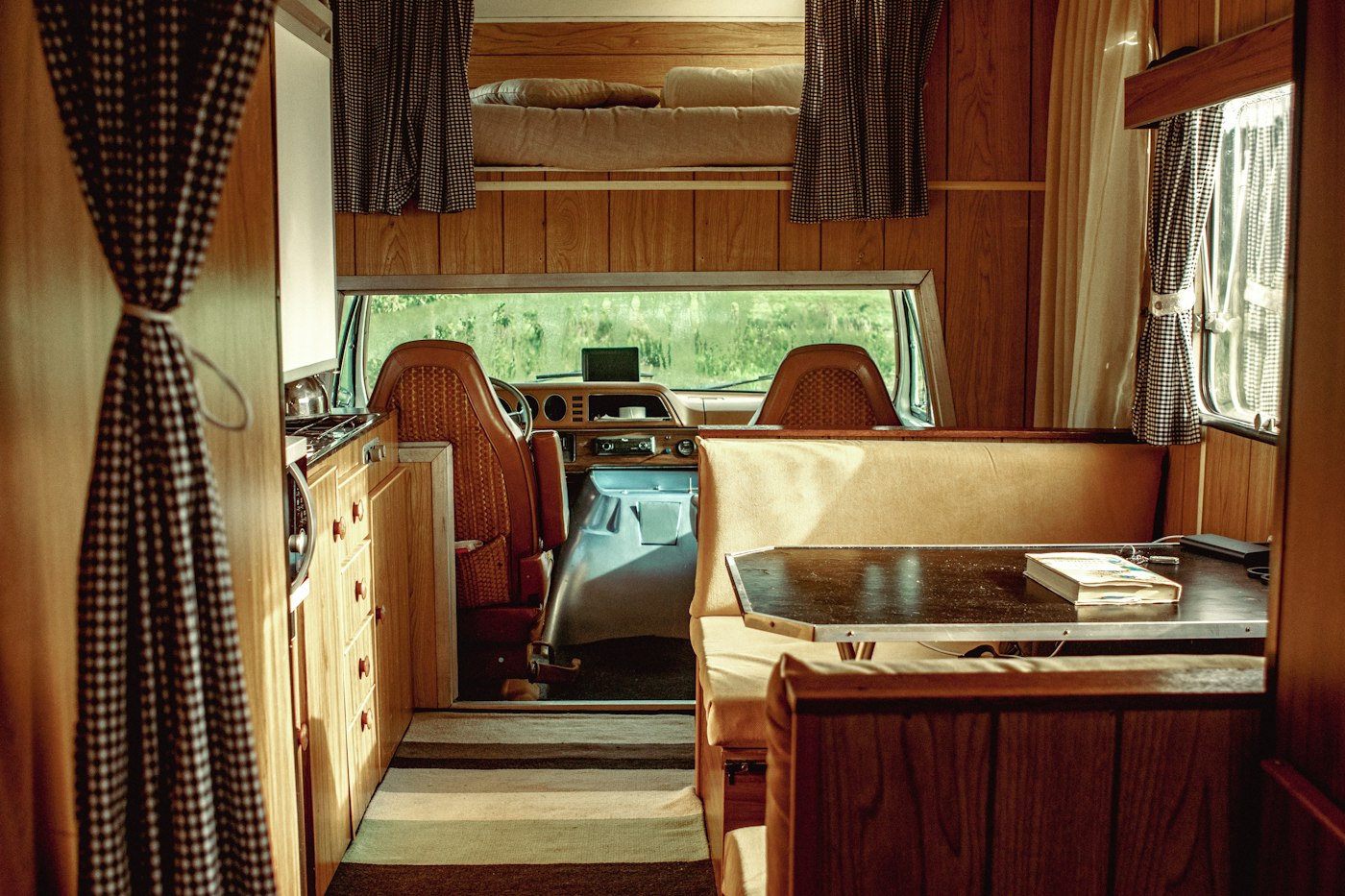 Clean RV interior with dinette, kitchen counter and cabinets