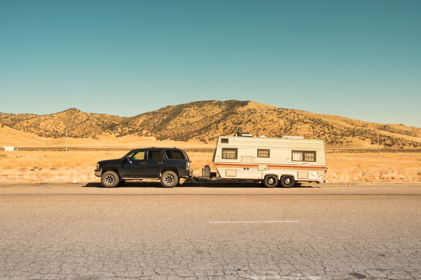 SUV towing a white travel trailer